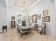Formal dining room featuring modern decor, travertine floors, and a decorative chandelier at 1014 Stella Vara Dr, Lutz, FL 33548