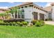 Close up shot of the home showcasing lush landscaping and a two-car garage at 1014 Stella Vara Dr, Lutz, FL 33548