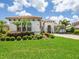 Exterior view of a white home with a clay tile roof, driveway, and manicured landscaping at 1014 Stella Vara Dr, Lutz, FL 33548