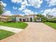 Front exterior showing clay tile roof, 3-car garage, driveway, landscaping and walkway at 1014 Stella Vara Dr, Lutz, FL 33548