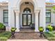 Elegant front entrance featuring decorative columns, a beautiful door, and manicured landscaping at 1014 Stella Vara Dr, Lutz, FL 33548