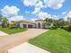 Stunning home with a beautiful terracotta tile roof, brick driveway and lush landscaping at 1014 Stella Vara Dr, Lutz, FL 33548