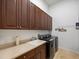 Well-equipped laundry room features modern appliances, storage cabinets, and counterspace at 1014 Stella Vara Dr, Lutz, FL 33548