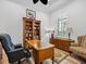 Spacious home office with a large wooden bookshelf, executive desk, and shuttered windows at 1014 Stella Vara Dr, Lutz, FL 33548