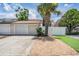 View of garage and front exterior featuring a well maintained garden and new driveway at 103 E Davis Blvd # B, Tampa, FL 33606