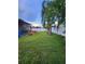 Wide fenced backyard with grass, hot tub and tropical trees at 10539 Egret Haven Ln, Riverview, FL 33578