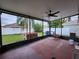 Screened patio with ceiling fan offers a relaxing outdoor space, hot tub, and lush backyard views at 10539 Egret Haven Ln, Riverview, FL 33578