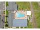 Aerial view featuring a geometric pool surrounded by trees and community buildings at 10947 Brickside Ct, Riverview, FL 33579