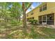 Backyard view features well-maintained lawn, mature trees, and a covered patio at 10947 Brickside Ct, Riverview, FL 33579