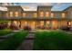 Charming townhome featuring a well-manicured lawn, walkway, and facade illuminated by warm, inviting lights at 10947 Brickside Ct, Riverview, FL 33579