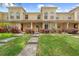 Charming townhome featuring a well-manicured lawn, walkway, and inviting facade under a clear blue sky at 10947 Brickside Ct, Riverview, FL 33579