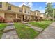 Exterior view of townhomes featuring a well-manicured lawn, walkways, and inviting facades at 10947 Brickside Ct, Riverview, FL 33579