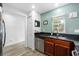 Well-lit kitchen with stainless steel dishwasher and sink, plus modern wood-look tile flooring at 10947 Brickside Ct, Riverview, FL 33579
