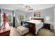 Main bedroom with a wooden bed frame, two windows, and hardwood floors at 10947 Brickside Ct, Riverview, FL 33579