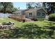 Well-maintained backyard with a wooden deck, fire pit, and lush green grass at 1103 E Lambright St, Tampa, FL 33604