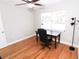 Bright bedroom features hardwood floors, a ceiling fan, and a desk by the sunny window at 1103 E Lambright St, Tampa, FL 33604