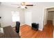 Bright bedroom with ceiling fan, hardwood floors, closet, and view into the hallway at 1103 E Lambright St, Tampa, FL 33604