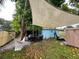 Inviting backyard with cozy hammock, patio set, shade sail, mature trees, and well-maintained lawn at 111 12Th Ave, Indian Rocks Beach, FL 33785