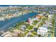 Aerial view of the home in a waterfront community with lush lawns and palms at 11240 6Th E St, Treasure Island, FL 33706