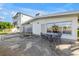 Waterfront home boasts a concrete patio with wrought iron furniture, two lounge chairs and a view of the water at 11240 6Th E St, Treasure Island, FL 33706
