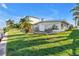 Backyard view of property from the water showing lawn, patio, and white exterior at 11240 6Th E St, Treasure Island, FL 33706