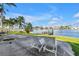 Waterfront backyard featuring a patio, lounge chairs, dock, and palm trees at 11240 6Th E St, Treasure Island, FL 33706