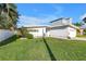 Lush green lawn complements this white home with a side-entry garage and palm trees at 11240 6Th E St, Treasure Island, FL 33706