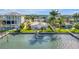 Waterfront home featuring a private dock, well-manicured lawn, and a glimpse of serene water views at 11240 6Th E St, Treasure Island, FL 33706