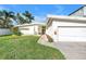 Well-kept lawn and landscaping highlight this home's front exterior with a driveway leading to the attached garage at 11240 6Th E St, Treasure Island, FL 33706