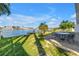 Waterfront backyard with lush lawn, patio area, and seating, offering picturesque water views and outdoor enjoyment at 11240 6Th E St, Treasure Island, FL 33706