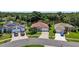 Aerial shot of suburban homes, showcasing their manicured lawns, mature trees, and proximity to a tranquil pond at 11550 Wellman Dr, Riverview, FL 33578