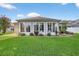Exterior view of home's sunroom, lush green grass, and landscaping at 11550 Wellman Dr, Riverview, FL 33578