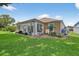 Home with a beautiful sunroom surrounded by well-maintained landscaping and lush green lawn at 11550 Wellman Dr, Riverview, FL 33578