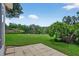 Expansive backyard featuring a serene pond view from the paved patio, ideal for relaxation and outdoor enjoyment at 11550 Wellman Dr, Riverview, FL 33578