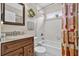 Bathroom with tiled shower and tub, stylish vanity, and decorative mirror at 11550 Wellman Dr, Riverview, FL 33578
