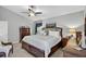 Spacious bedroom featuring a ceiling fan, carpeting, and matching wooden dressers with mirror and nightstand at 11550 Wellman Dr, Riverview, FL 33578
