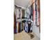 Walk-in closet featuring rods and shelves filled with a variety of hanging clothes and accessories at 11550 Wellman Dr, Riverview, FL 33578