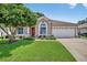 Charming home featuring a well-manicured lawn, mature tree, and an attached two-car garage at 11550 Wellman Dr, Riverview, FL 33578