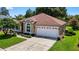 Attractive home featuring a two-car garage, manicured landscaping, and a tidy front lawn enhancing its curb appeal at 11550 Wellman Dr, Riverview, FL 33578