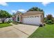Exterior shot of a two-car garage with white door, set against a blue sky backdrop at 11550 Wellman Dr, Riverview, FL 33578