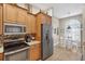 Well-equipped kitchen featuring stainless steel appliances and warm wood cabinets, with adjacent dining area at 11550 Wellman Dr, Riverview, FL 33578