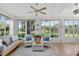 Bright sunroom offering serene views of the lake, complemented by cozy seating and natural light at 11550 Wellman Dr, Riverview, FL 33578