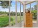 Sunroom with large windows overlooking the grassy backyard and a pond view at 11550 Wellman Dr, Riverview, FL 33578