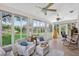 Bright sunroom with large windows offering scenic views, seating area and ceiling fans at 11550 Wellman Dr, Riverview, FL 33578