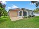 Enclosed sunroom with large windows and tile patio offers an extended living space to enjoy the backyard at 11550 Wellman Dr, Riverview, FL 33578