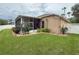 View of the backyard with a screened-in lanai and manicured landscaping and white vinyl fence at 11610 Grove Arcade Dr, Riverview, FL 33569