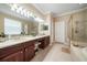 Bright bathroom with double vanity, large mirror, and a glass enclosed shower at 11610 Grove Arcade Dr, Riverview, FL 33569