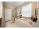 Bright bathroom showcasing a bathtub, a glass shower, and neutral tile flooring at 11610 Grove Arcade Dr, Riverview, FL 33569