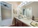 Bathroom featuring a double sink vanity with wood cabinets and a well-lit mirror, exuding charm and functionality at 11610 Grove Arcade Dr, Riverview, FL 33569
