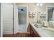 Bathroom featuring double sinks, dark wood cabinets and wood-look floors at 11610 Grove Arcade Dr, Riverview, FL 33569